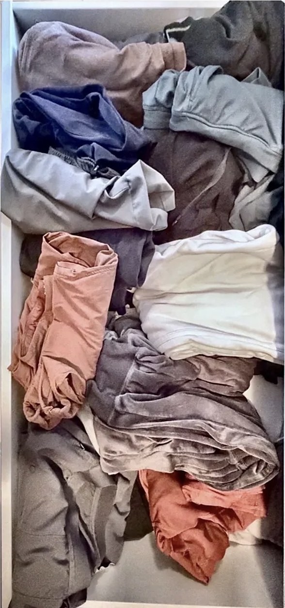 Drawer stuffed with unfolded clothes before organizing