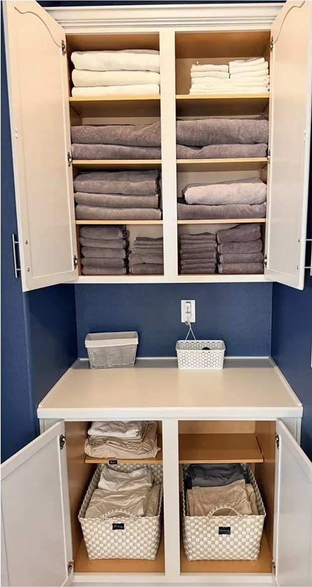 Linen cabinet with neatly folded and sorted linens after organizing